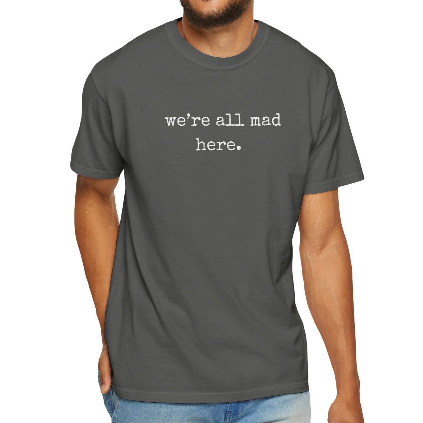 Man wearing a gray t-shirt with 'we're all mad here' text on a white background