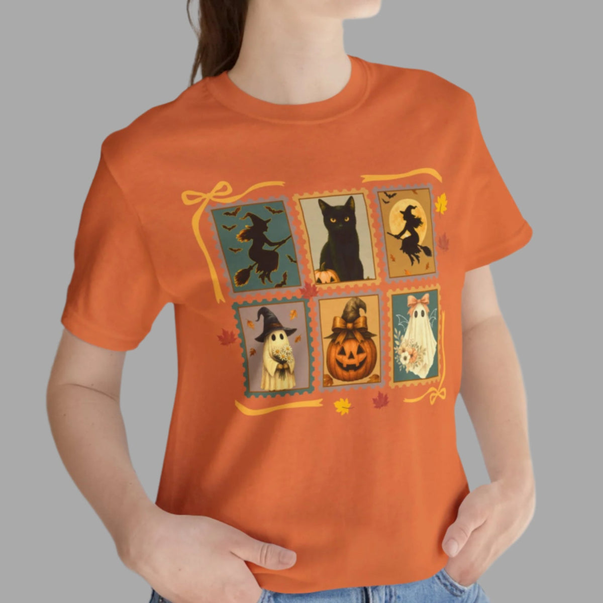 Person wearing an orange t-shirt with Halloween-themed graphics on a gray background