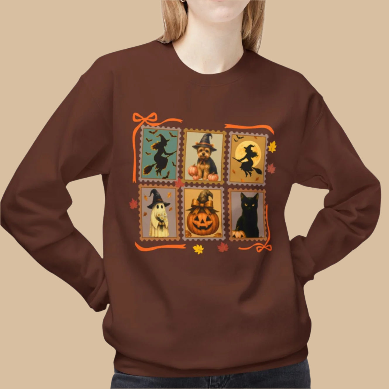 Brown sweatshirt with Halloween-themed design featuring pumpkins, cats, and ghosts on a white background.