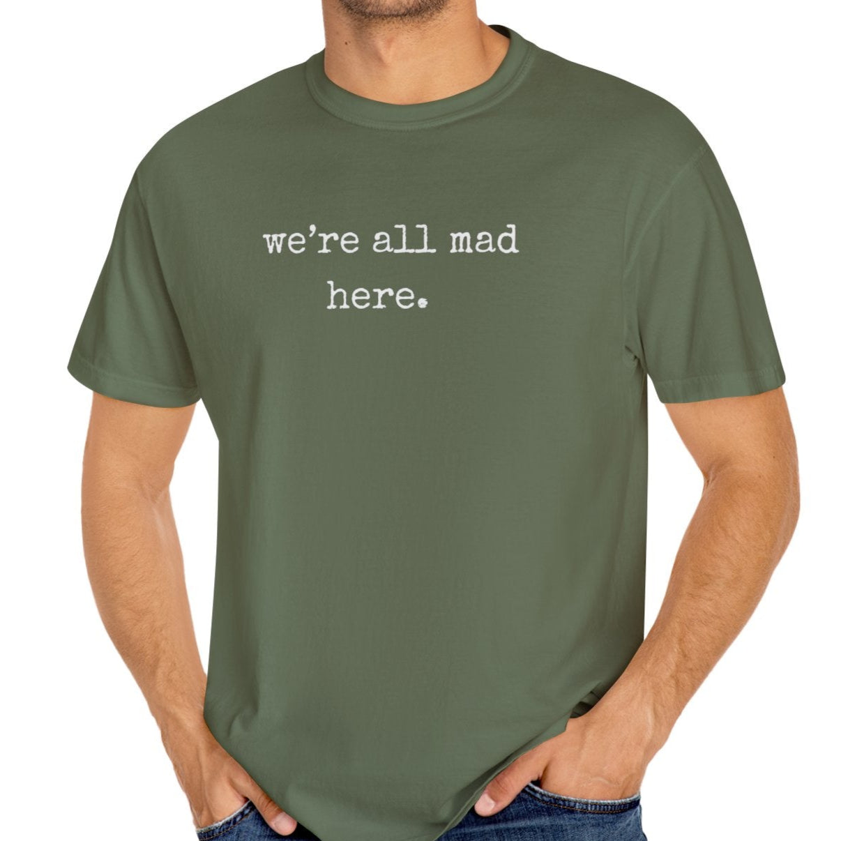 Man wearing a green t-shirt with 'we're all mad here.' text on a white background
