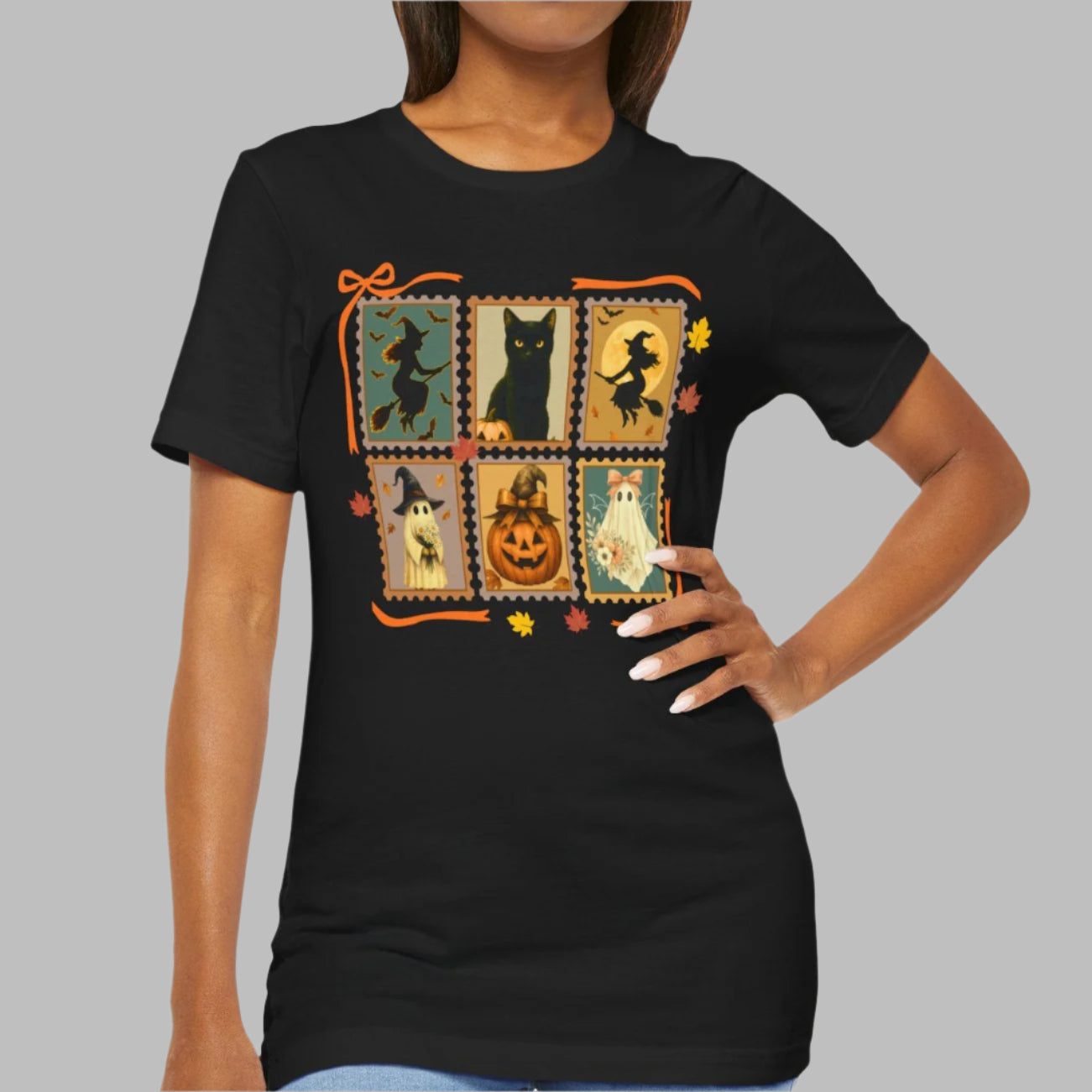 Black t-shirt with Halloween-themed design featuring cats, pumpkins, and witches on a gray background.