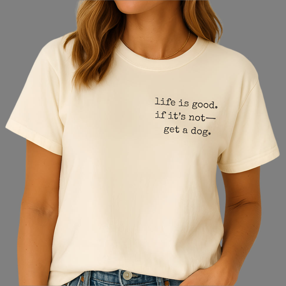 Person wearing a white t-shirt with 'life is good. if it's not--get a dog.' text.