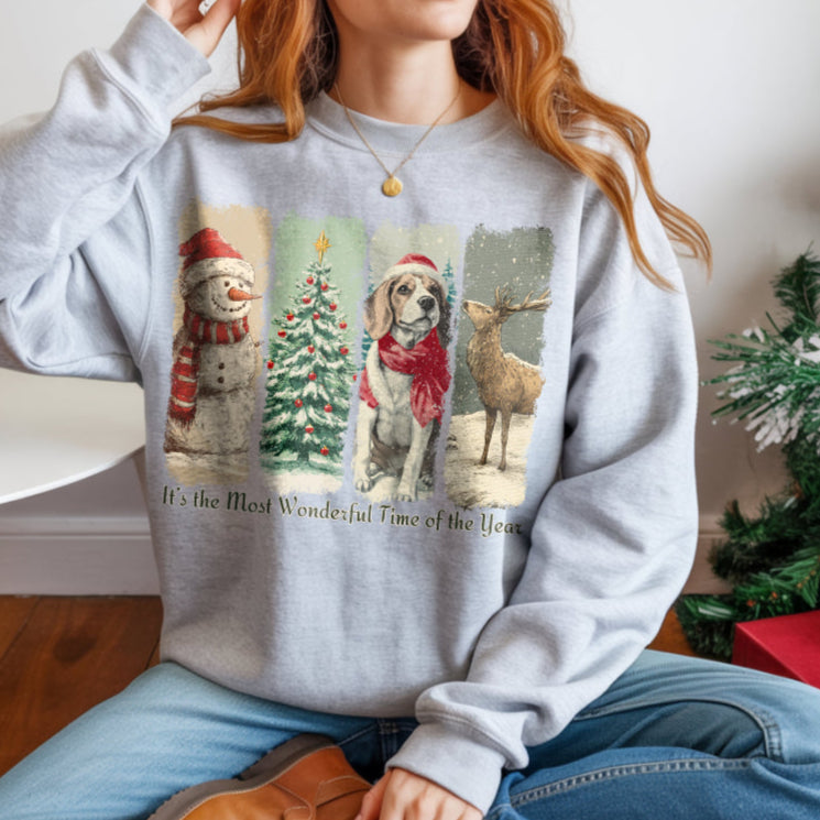 Person wearing a gray sweatshirt with Christmas-themed design, sitting in a room with a Christmas tree and presents.