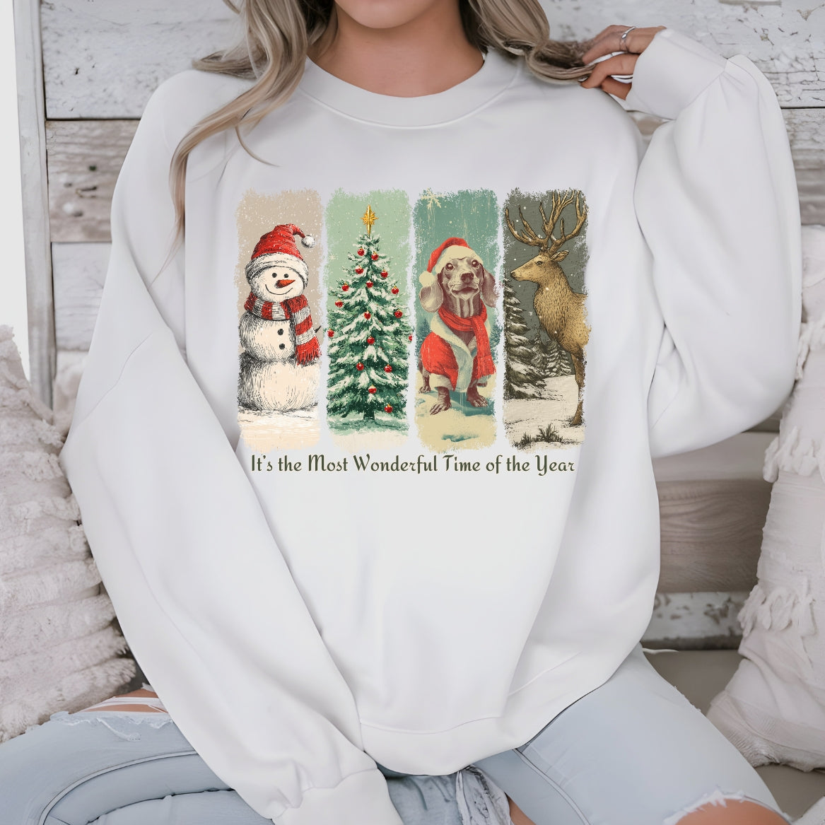 Person wearing a white sweatshirt with Christmas-themed graphics and text.