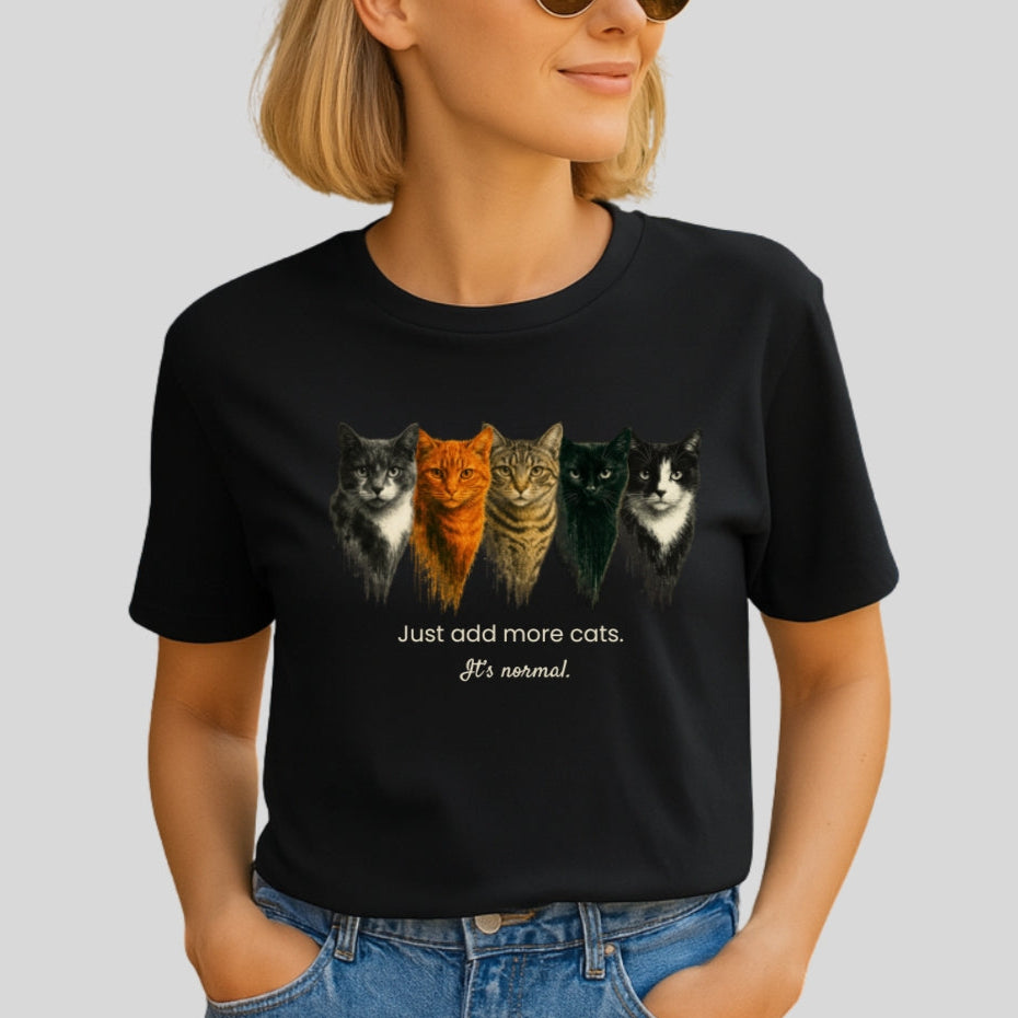 Woman wearing a black t-shirt with cat illustrations and text on a plain background
