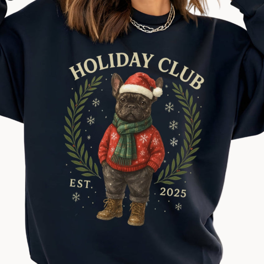 black sweatshirt with a Christmas-themed design of a dog and text 'Holiday Club EST 2025' on a beige background.