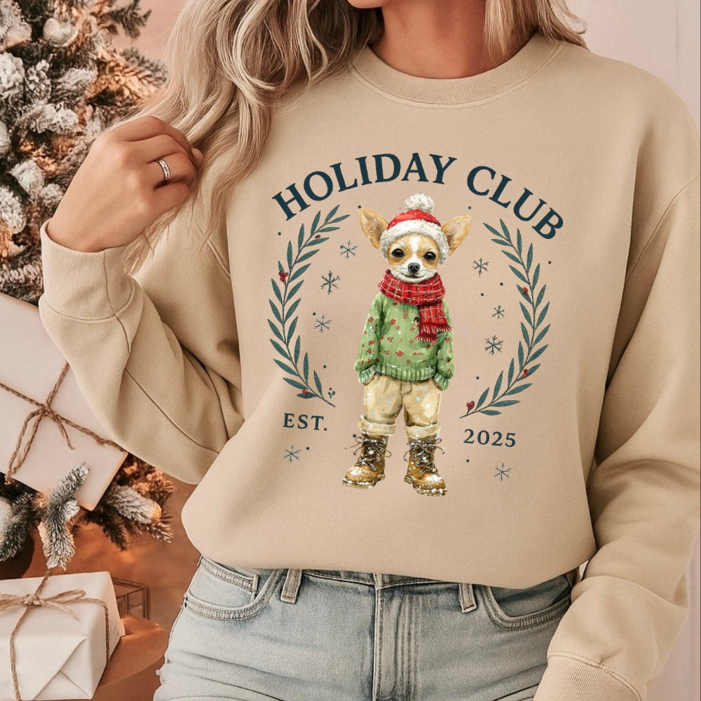 Person wearing a beige sweatshirt with 'Holiday Club' design, sitting in front of Christmas decorations.
