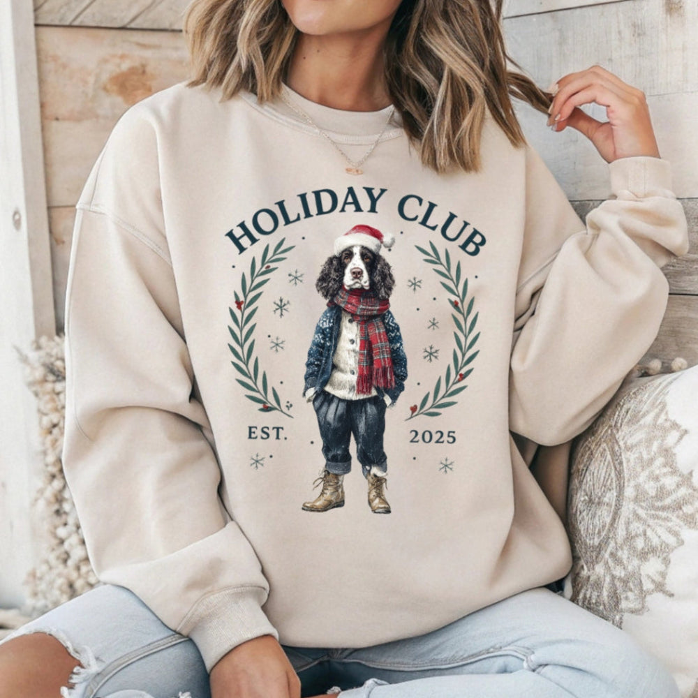 Person wearing a beige sweatshirt with a holiday-themed design featuring a dog and text.