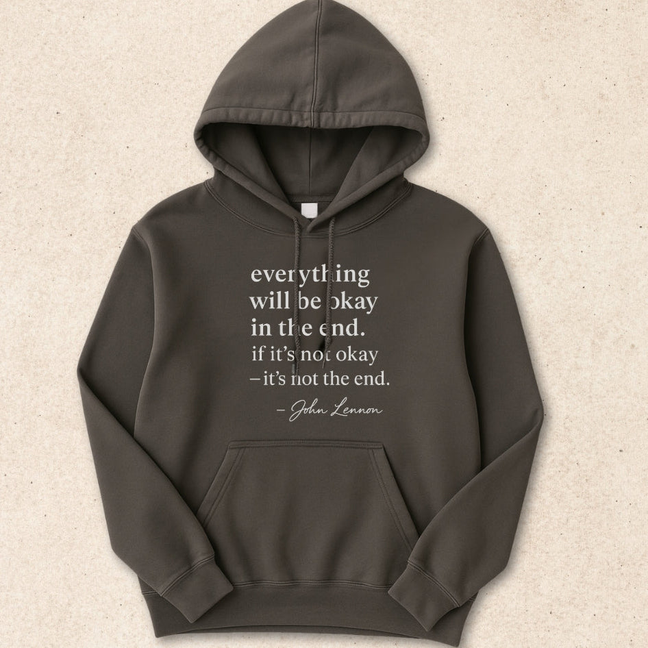 Dark gray hoodie with a quote on a beige background