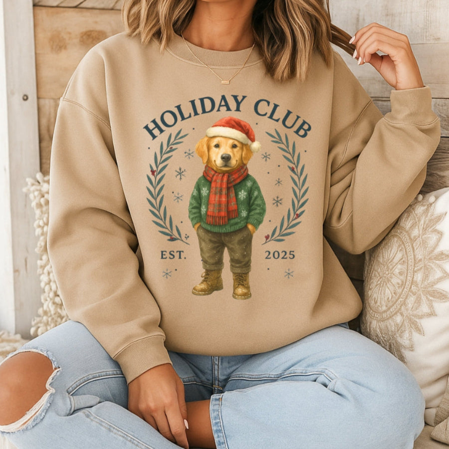 Person wearing a beige sweatshirt with a bear graphic and 'Holiday Club' text, sitting on a wooden floor.