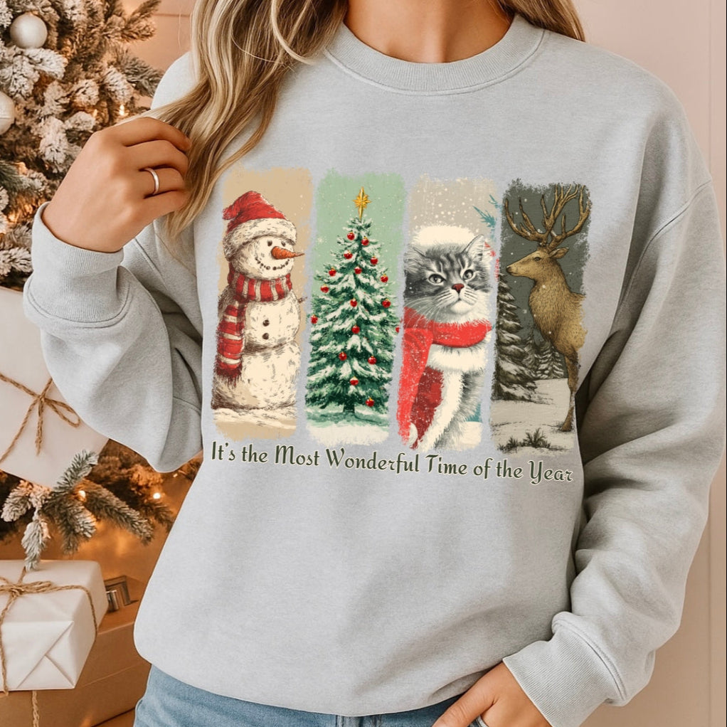 Person wearing a light gray sweatshirt with Christmas-themed illustrations in front of a decorated Christmas tree.