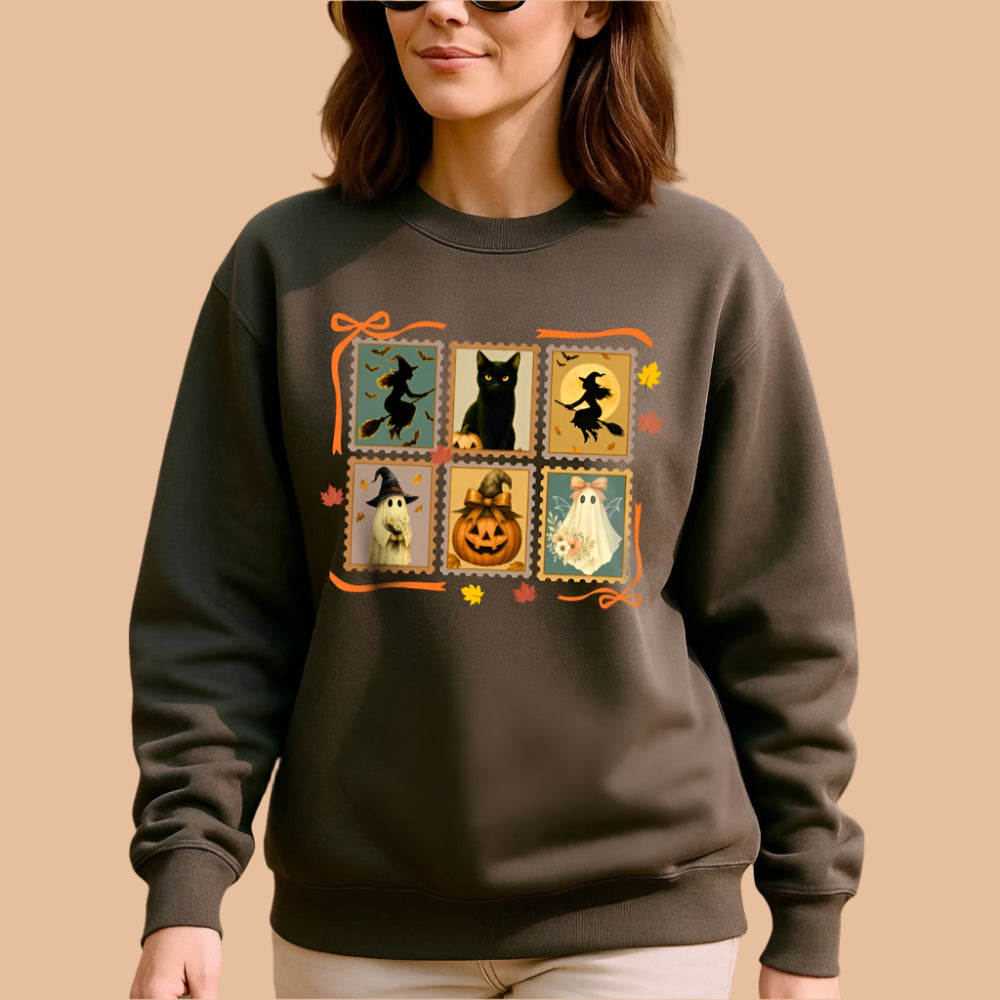 Woman wearing a charcoal sweatshirt with Halloween-themed design in an autumn setting