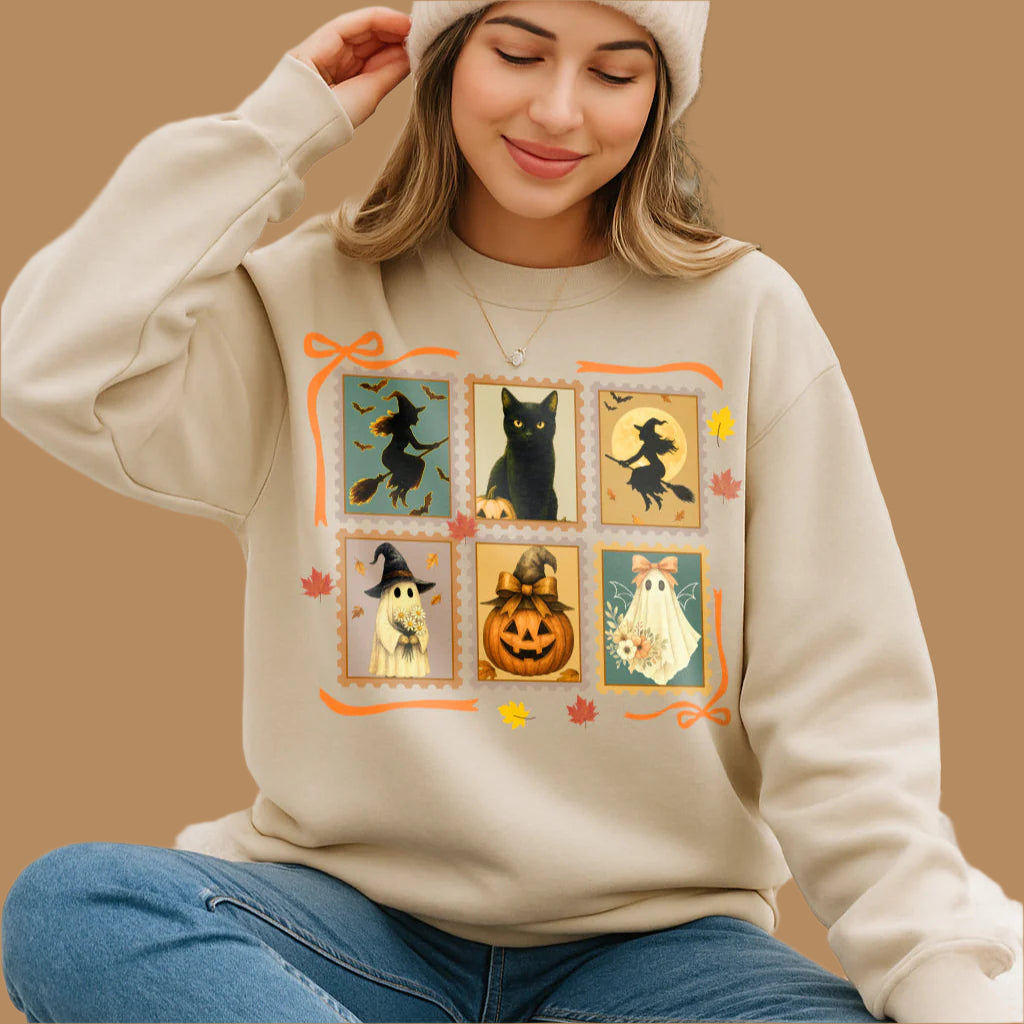 Woman wearing a beige sweatshirt with Halloween-themed design, sitting outdoors.