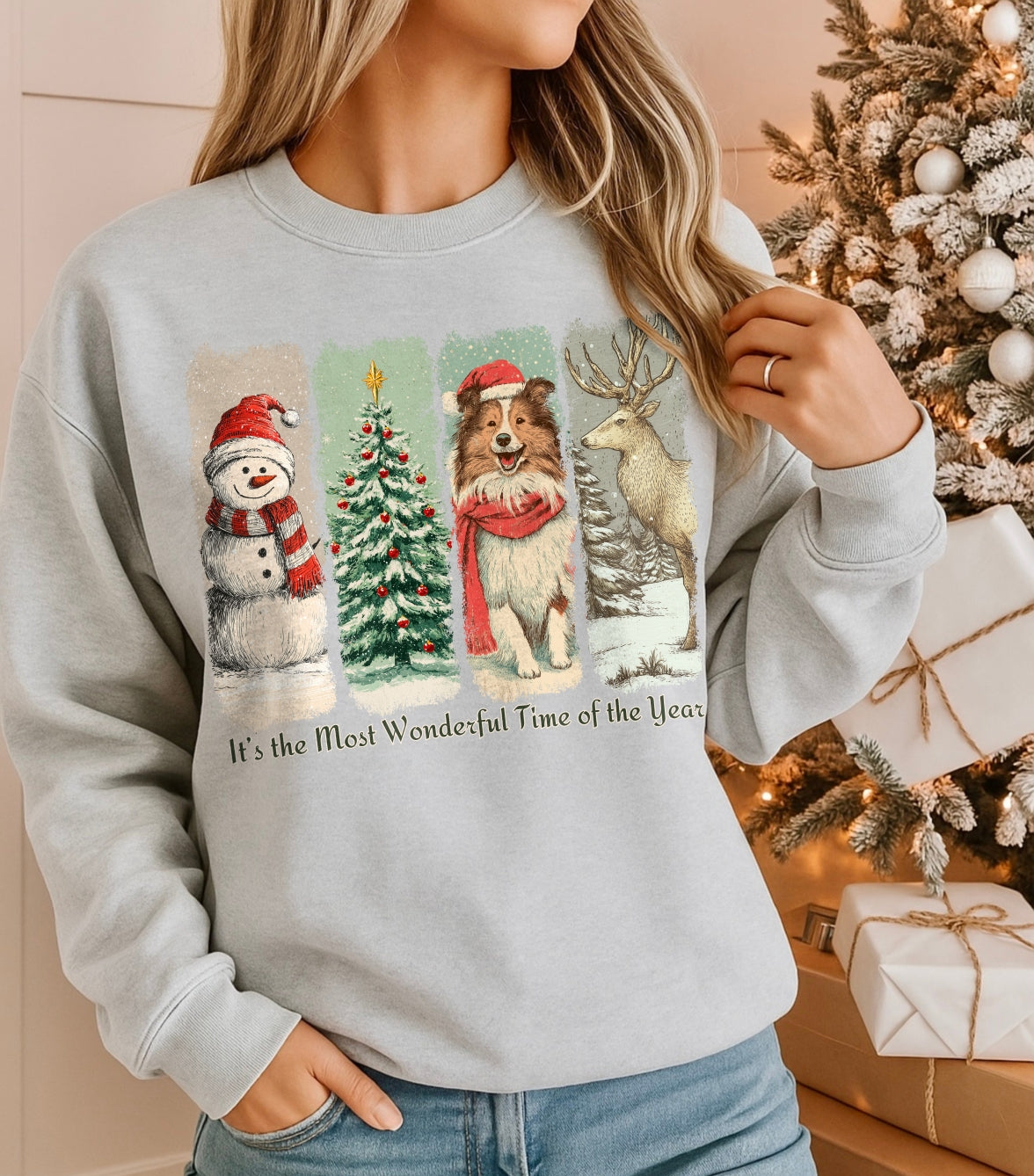 Person wearing a light gray sweatshirt with Christmas-themed graphics in front of a decorated Christmas tree.