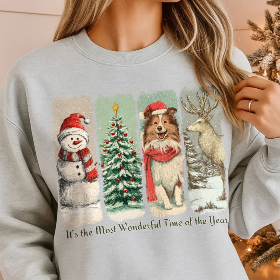 Person wearing a light gray sweatshirt with Christmas-themed graphics in front of a decorated Christmas tree.