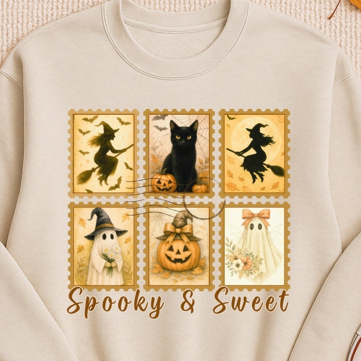 Beige sweatshirt with Halloween-themed design on a textured surface with autumn leaves and a pumpkin.