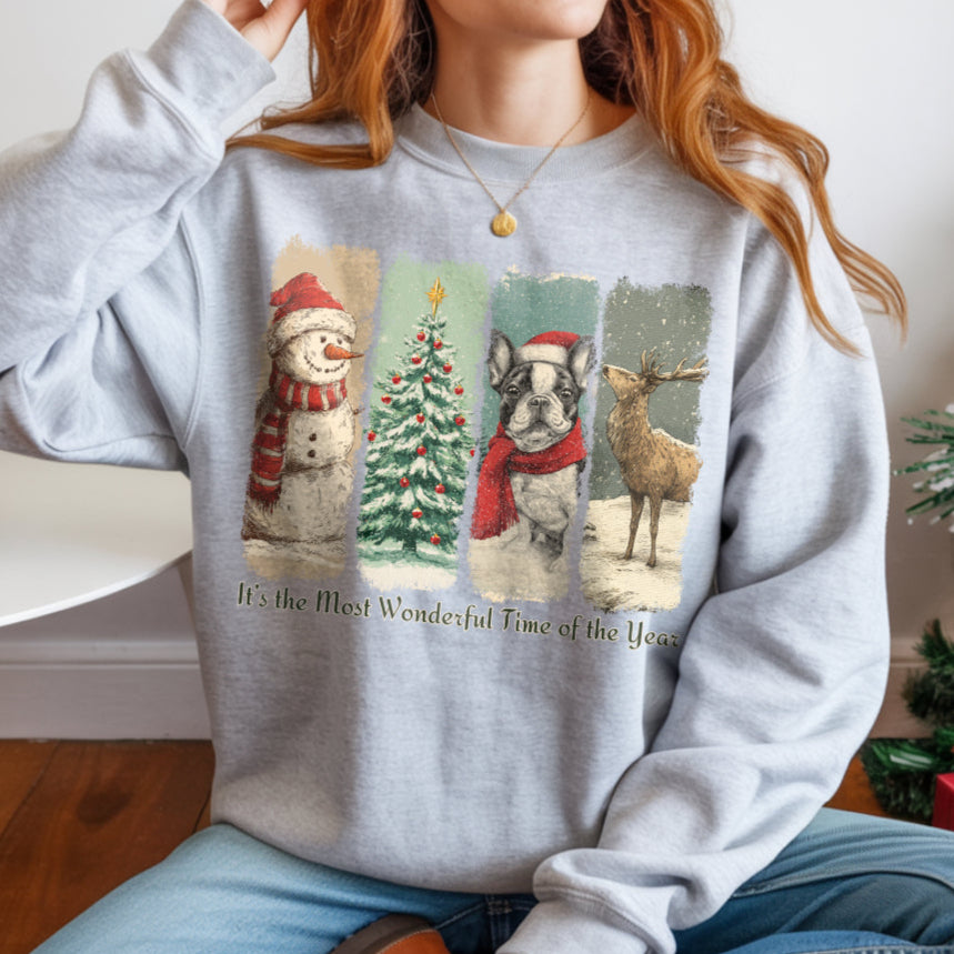 Person wearing a gray sweatshirt with Christmas-themed designs and text, sitting in a room with a Christmas tree and presents.