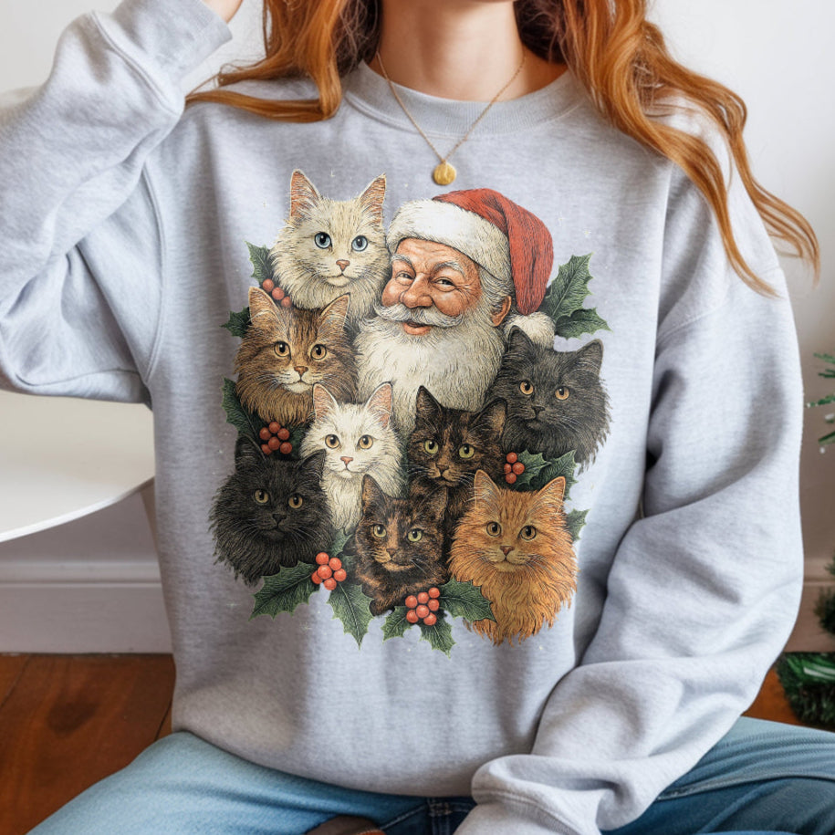 Person wearing a gray sweatshirt with a Christmas-themed design of Santa Claus and cats.