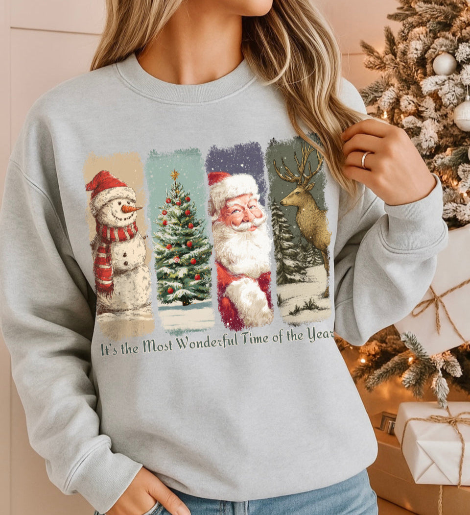 Person wearing a Christmas-themed sweatshirt with festive graphics and text, standing in front of a decorated Christmas tree and presents.