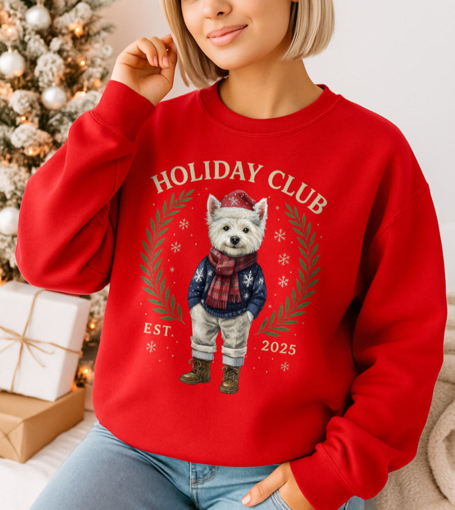 Woman wearing a red 'Holiday Club' sweatshirt with a bear graphic in front of a Christmas tree.