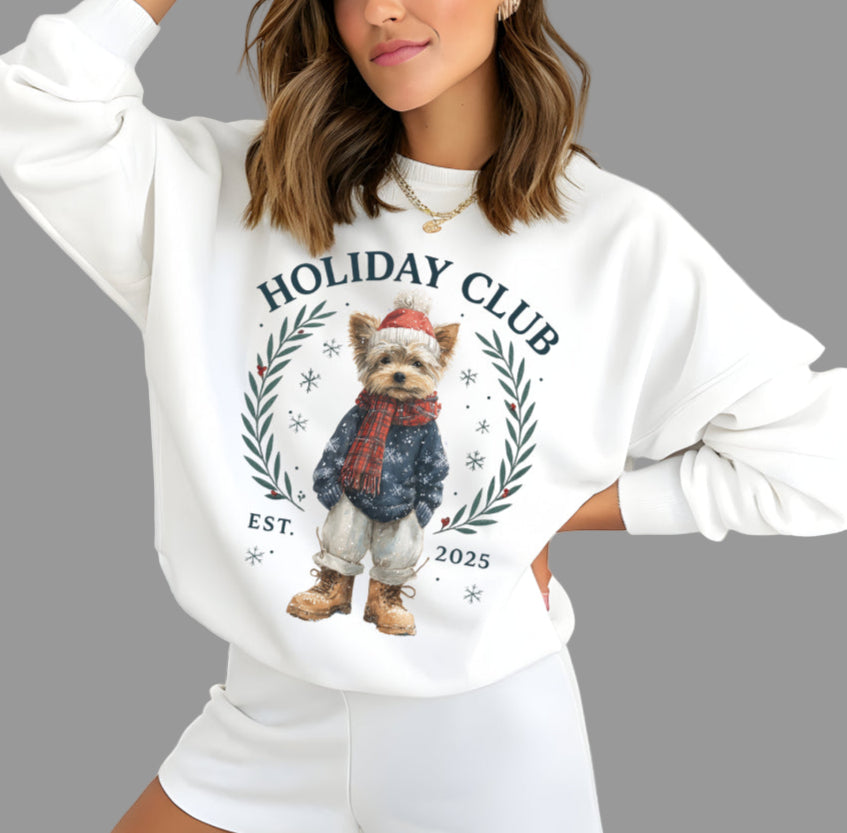 Woman wearing a white sweatshirt with a dog graphic and 'Holiday Club' text.