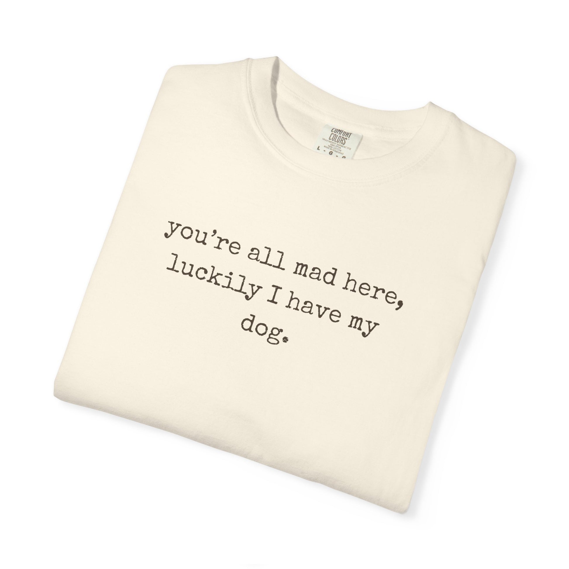Folded cream-colored t-shirt with text on a white background