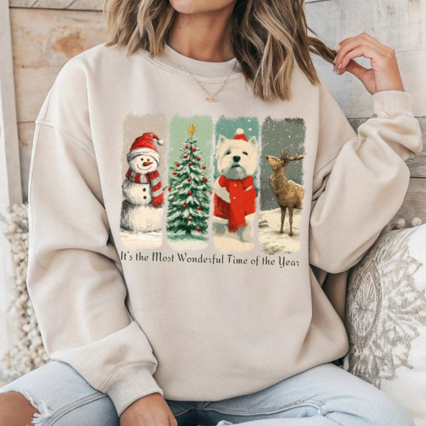 Person wearing a beige sweatshirt with Christmas-themed design featuring a snowman, tree, dog, and deer.
