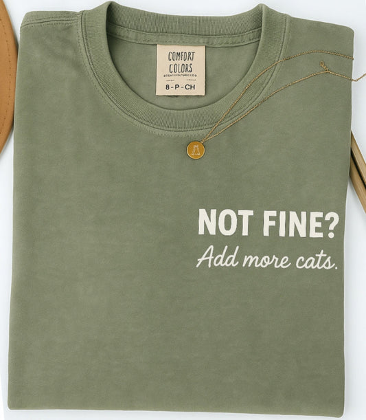 Green t-shirt with text 'Not Fine? Add more cats' on a white background