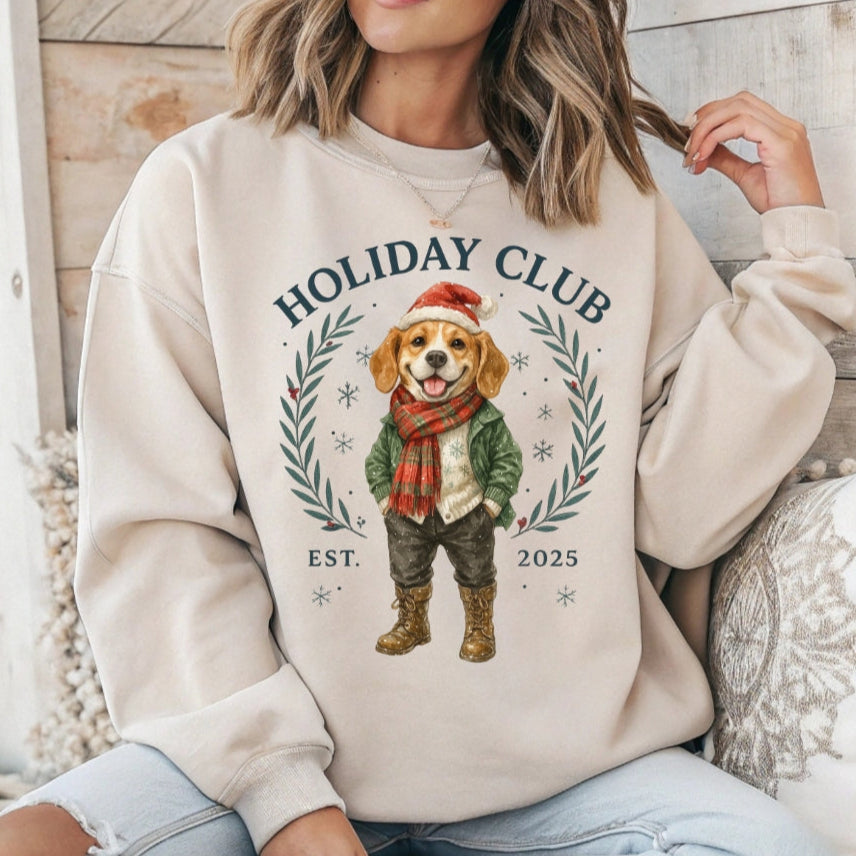 Person wearing a beige sweatshirt with a dog graphic and 'Holiday Club' text.