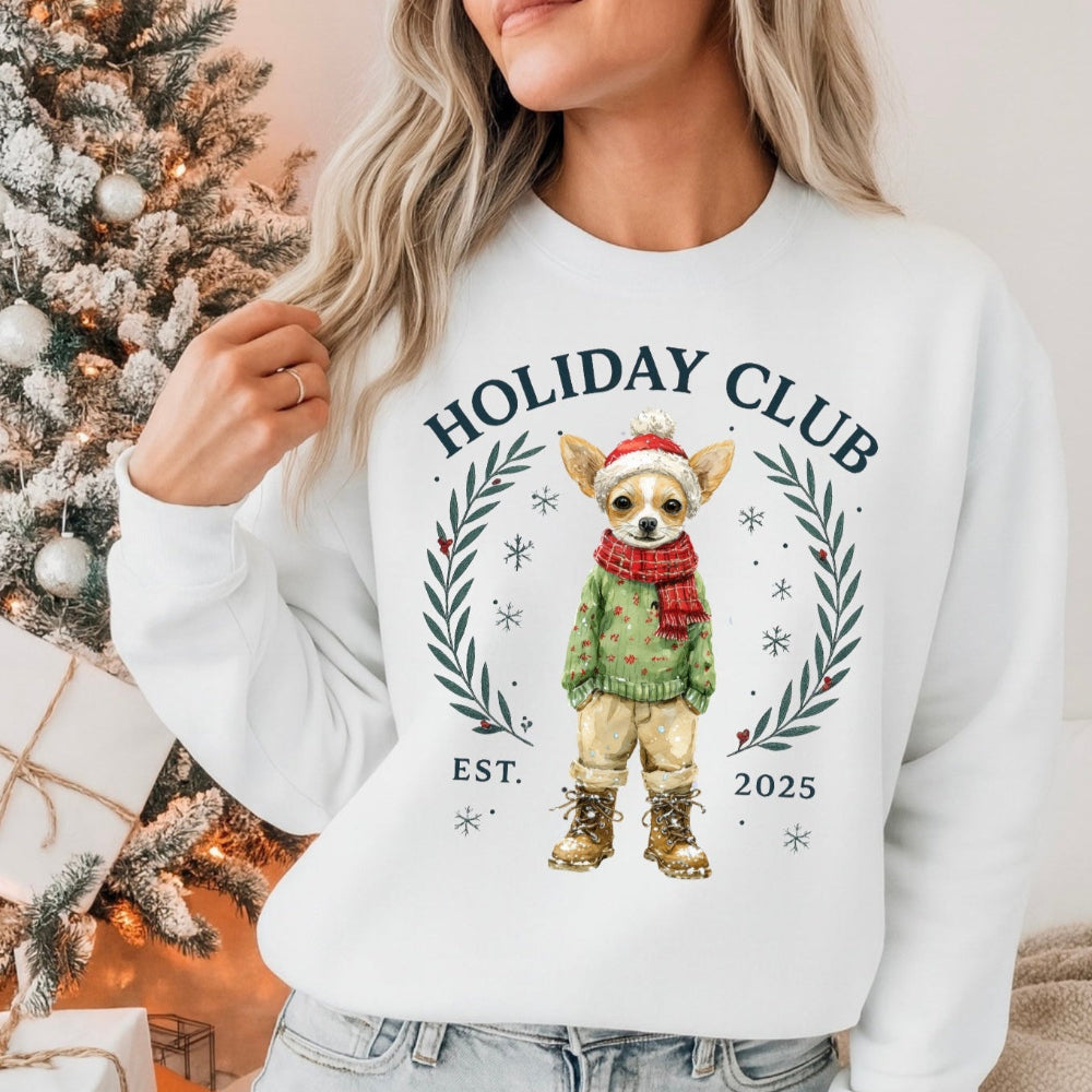Person wearing a white sweatshirt with a dog graphic and 'Holiday Club' text, Christmas tree and gifts in the background.