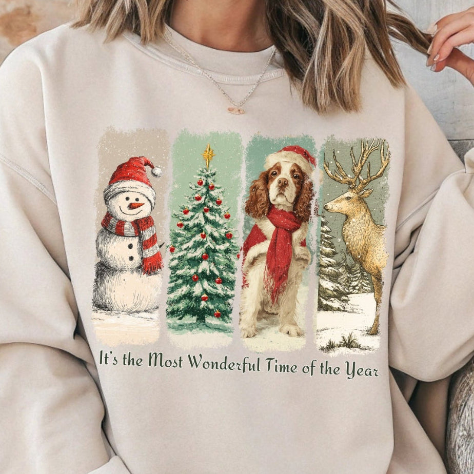 Person wearing a beige sweatshirt with Christmas-themed graphics and text.