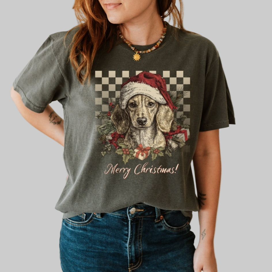 Person wearing a green t-shirt with a Christmas-themed dog graphic and 'Merry Christmas!' text.