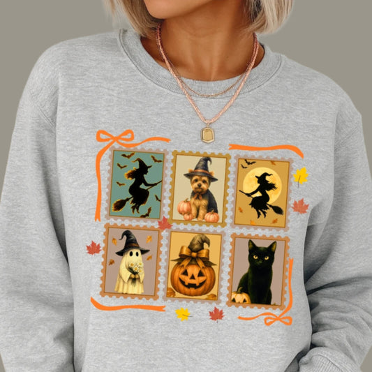 Gray sweatshirt with Halloween-themed design featuring pumpkins, cats, and witches.