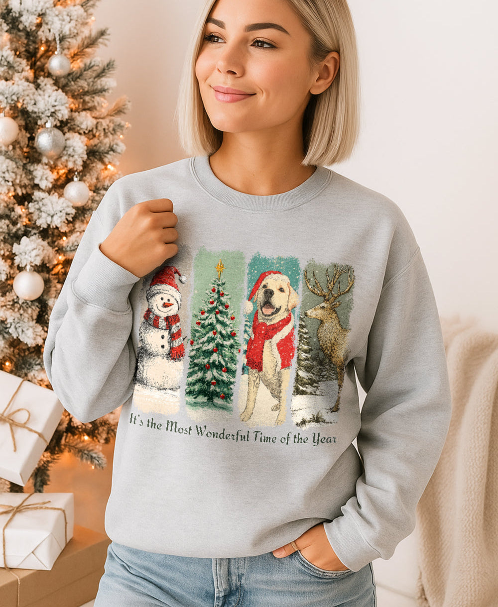 Woman wearing a light gray sweatshirt with Christmas-themed graphics in front of a decorated tree.