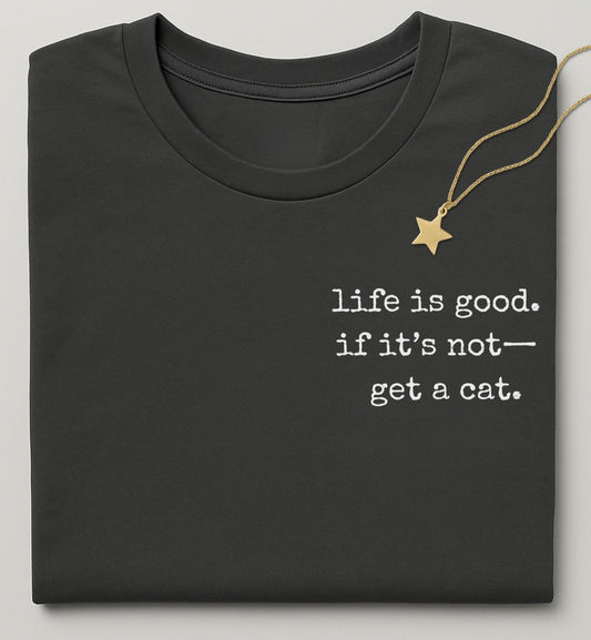 Black t-shirt with 'life is good, if it's not... get a cat.' text and a gold necklace on a light gray background