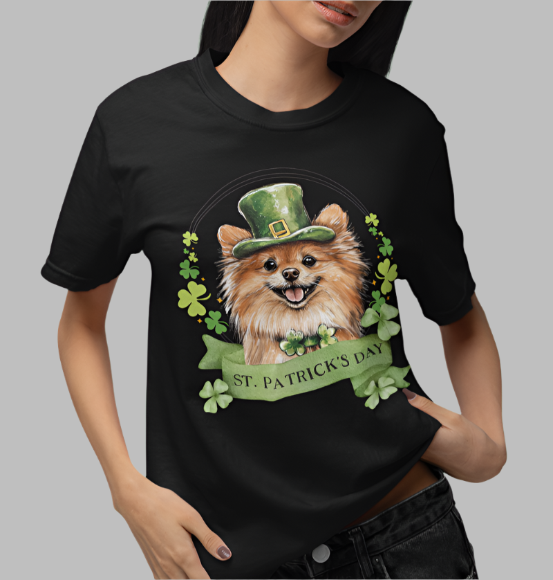 Woman in a black St. Patrick’s Day t-shirt featuring a Pomeranian dog with a shamrock garland and festive Irish design