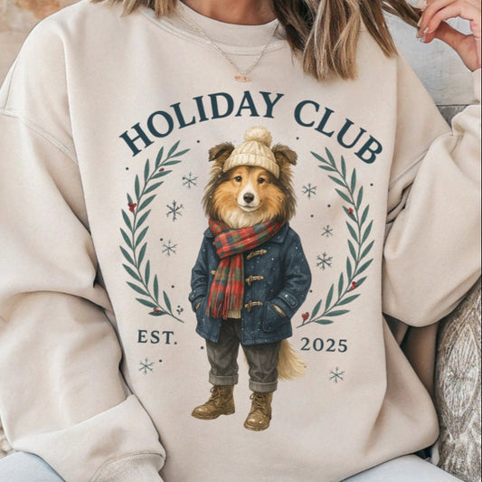 Person wearing a beige sweatshirt with a bear graphic and 'Holiday Club' text, sitting on a wooden floor.